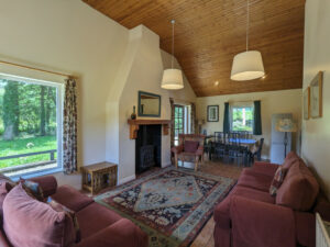 Living room area with large window looking out to trees and river Carnaclasha, no. 9, Rostrevor Holidays